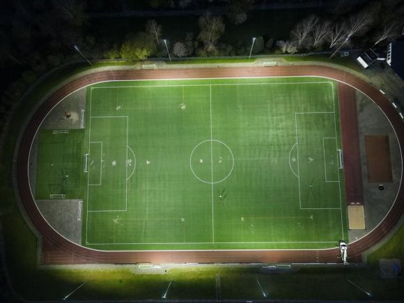 Fußballplatz mit Flutlicht von oben aufgenommen